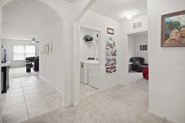 hallway featuring separate washer and dryer and light carpet