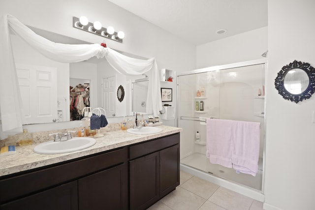 bathroom featuring tile patterned flooring, vanity, and walk in shower