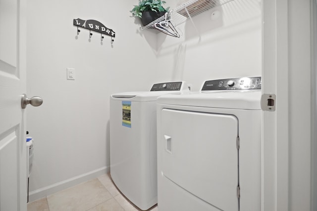 clothes washing area with light tile patterned flooring and washing machine and clothes dryer