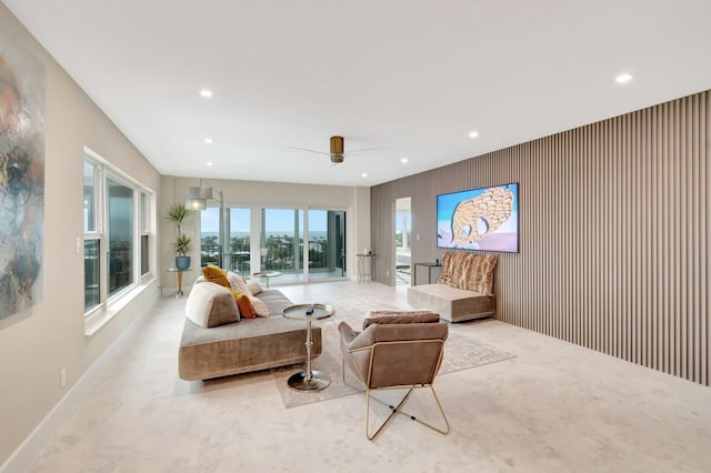 living room with ceiling fan and wood walls