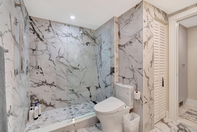 bathroom with tiled shower and toilet