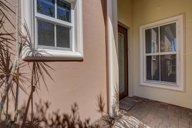 view of exterior entry featuring stucco siding