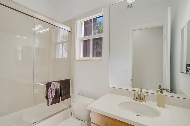 full bath featuring toilet, vanity, and shower / bath combination with glass door