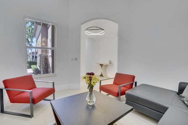 living area with arched walkways and baseboards