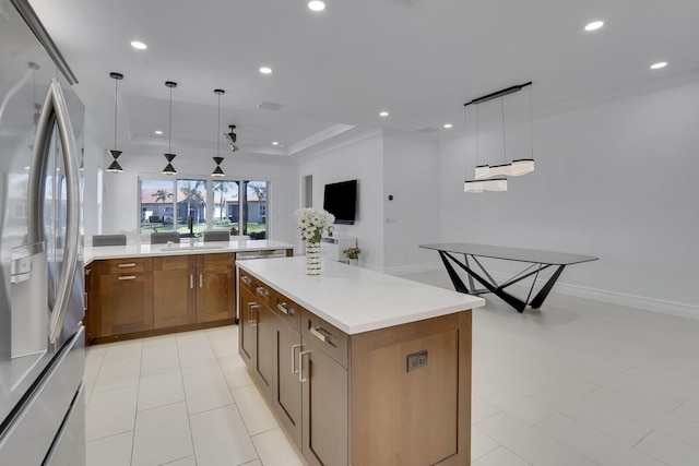 kitchen with recessed lighting, brown cabinets, freestanding refrigerator, and a center island