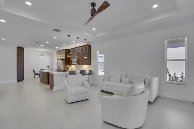 living room with baseboards, recessed lighting, a ceiling fan, visible vents, and a raised ceiling
