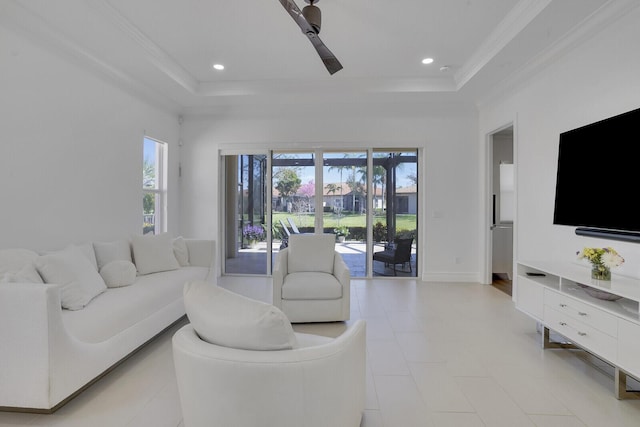 living area featuring recessed lighting, a tray ceiling, and crown molding