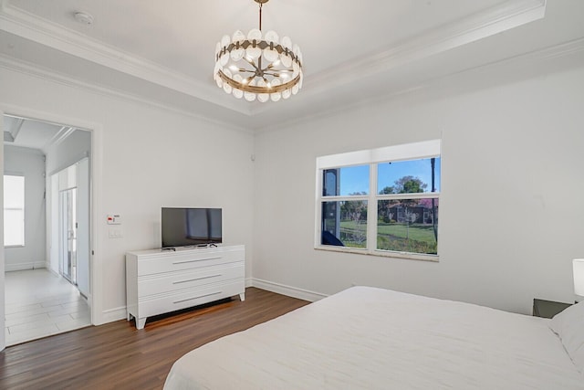 bedroom featuring crown molding, baseboards, a notable chandelier, a raised ceiling, and dark wood-style flooring