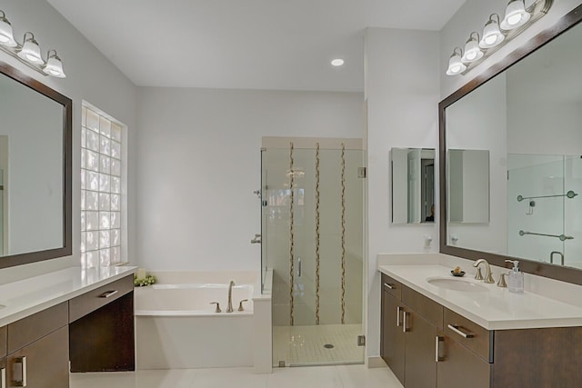 full bath featuring a marble finish shower, a garden tub, two vanities, tile patterned floors, and a sink