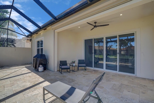 view of patio with a lanai, a ceiling fan, and a grill