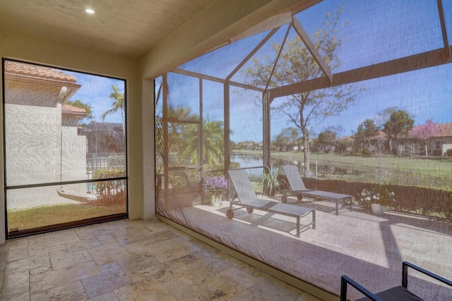 unfurnished sunroom featuring a water view