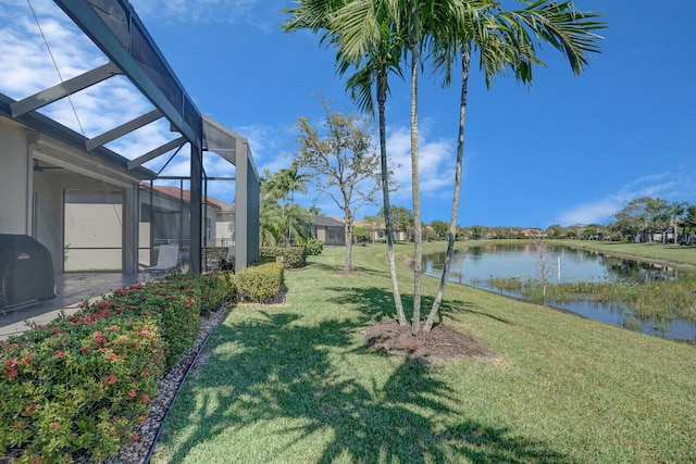 view of yard featuring glass enclosure and a water view