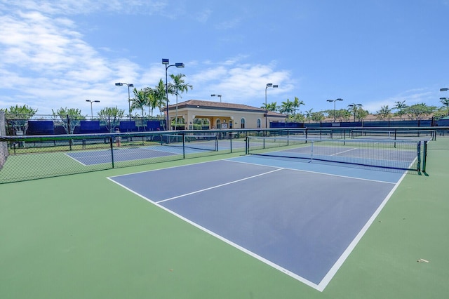 view of tennis court featuring community basketball court and fence