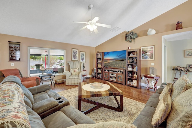 living room featuring a textured ceiling, ceiling fan, lofted ceiling, and wood-type flooring