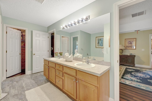 bathroom featuring a textured ceiling and vanity