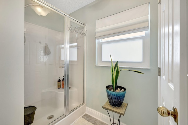 bathroom featuring an enclosed shower and a textured ceiling