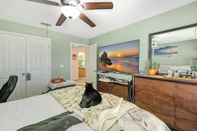 bedroom with ceiling fan, a textured ceiling, and a closet