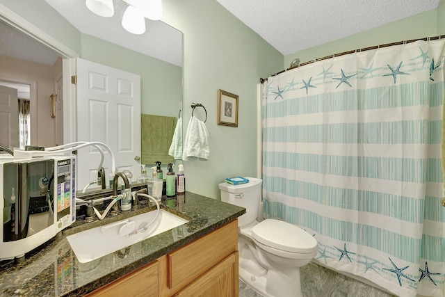 bathroom featuring toilet, vanity, walk in shower, and a textured ceiling