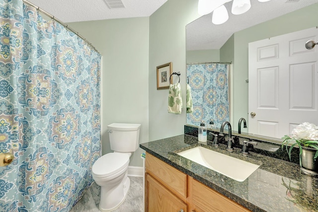 bathroom with a textured ceiling, toilet, and vanity