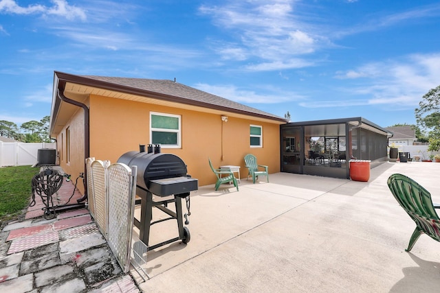 back of house featuring central AC unit, a sunroom, and a patio