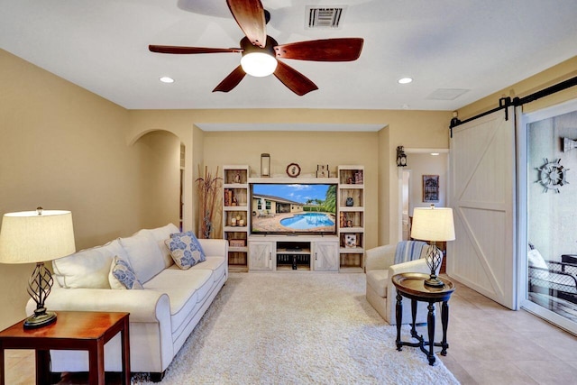 living room featuring ceiling fan and a barn door