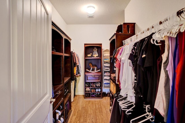 walk in closet featuring light hardwood / wood-style flooring