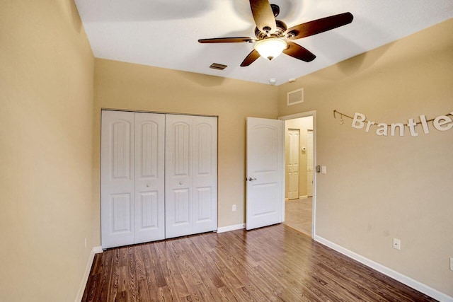 unfurnished bedroom featuring ceiling fan, a closet, and hardwood / wood-style floors