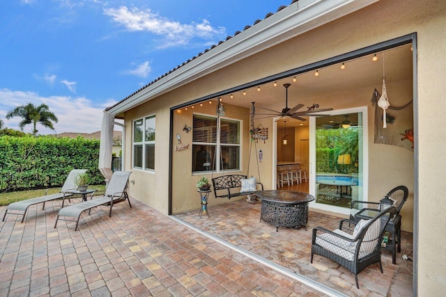 view of patio / terrace featuring ceiling fan and an outdoor fire pit