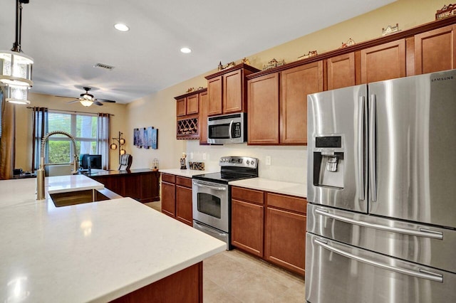 kitchen featuring pendant lighting, appliances with stainless steel finishes, sink, ceiling fan, and light tile patterned floors