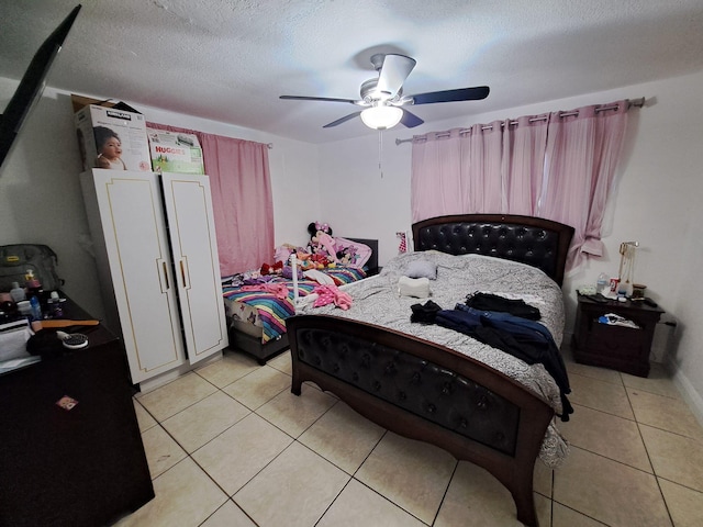 tiled bedroom with a textured ceiling and ceiling fan