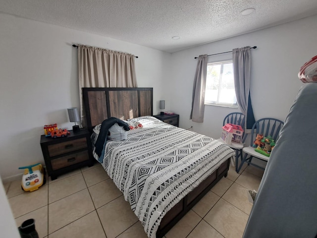 bedroom featuring a textured ceiling and light tile patterned floors