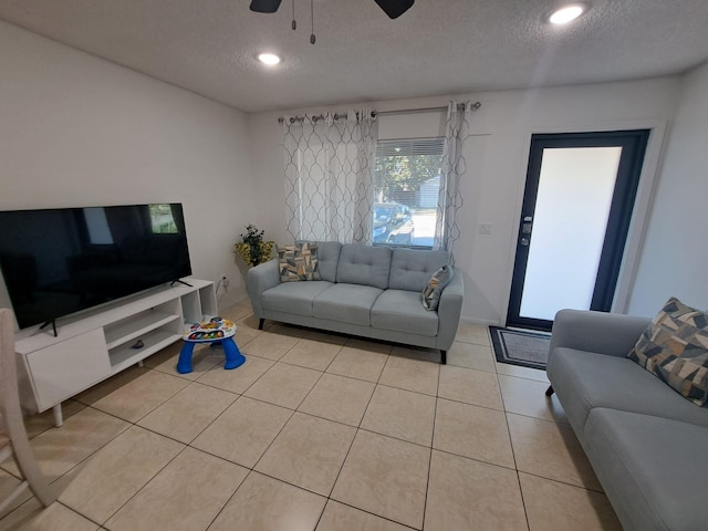 tiled living room with a textured ceiling and ceiling fan