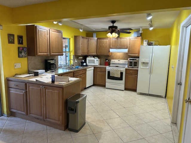 kitchen featuring a sink, ceiling fan, a peninsula, white appliances, and under cabinet range hood