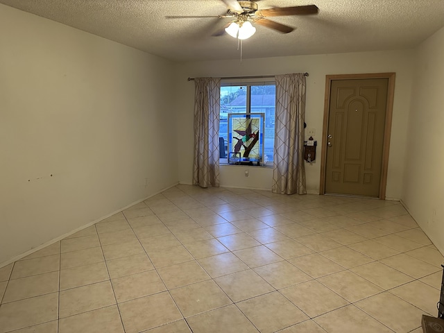 tiled spare room featuring ceiling fan and a textured ceiling