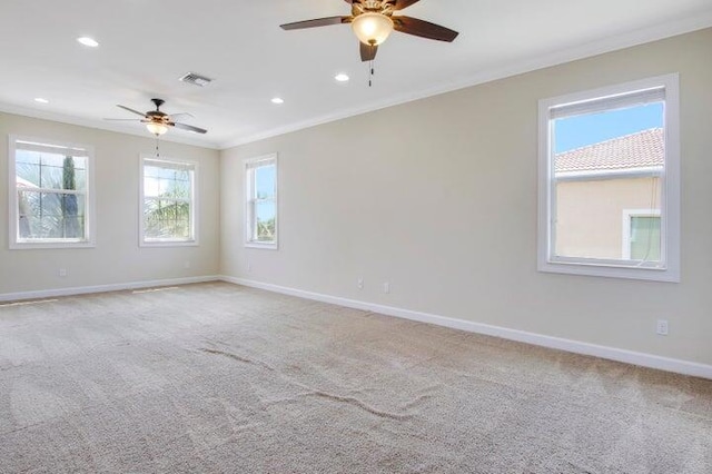 unfurnished room with ceiling fan, a wealth of natural light, ornamental molding, and light carpet