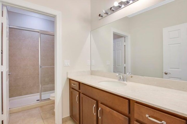 bathroom featuring a shower with door, toilet, tile patterned flooring, and vanity