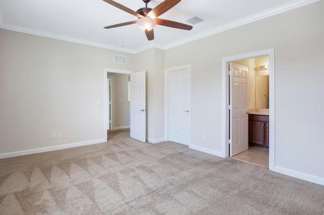 unfurnished bedroom with crown molding, ensuite bath, a closet, light colored carpet, and ceiling fan