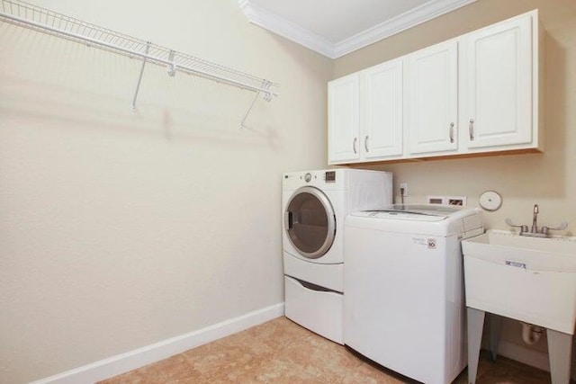 laundry room featuring sink, washer and clothes dryer, crown molding, and cabinets