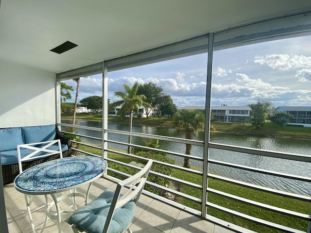 sunroom / solarium featuring a water view