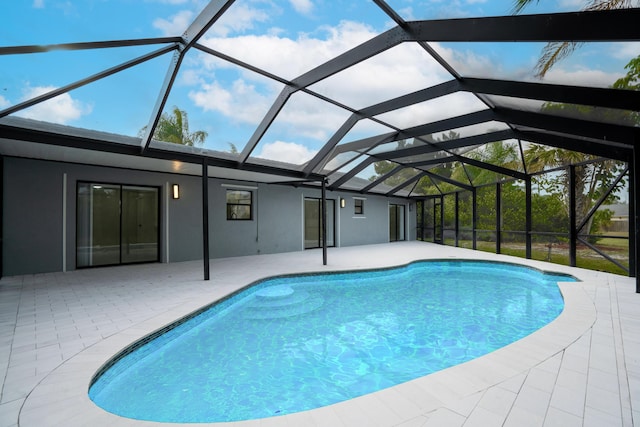 view of pool with glass enclosure and a patio