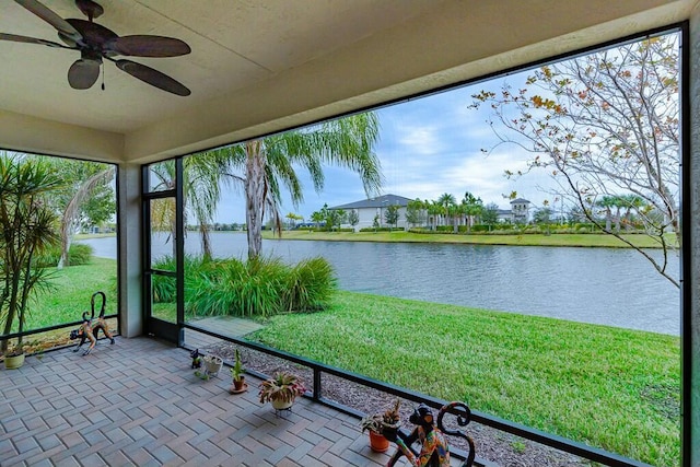 unfurnished sunroom with a water view and ceiling fan