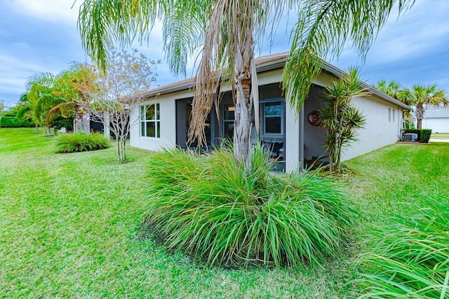 view of home's exterior with central AC unit and a lawn