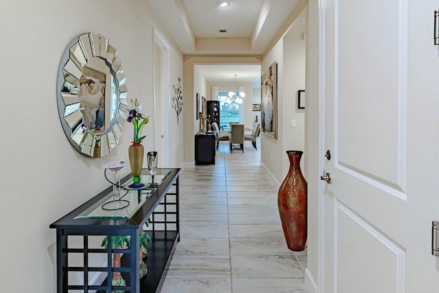 hallway with an inviting chandelier