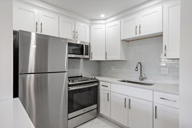 kitchen with appliances with stainless steel finishes, backsplash, white cabinets, and sink