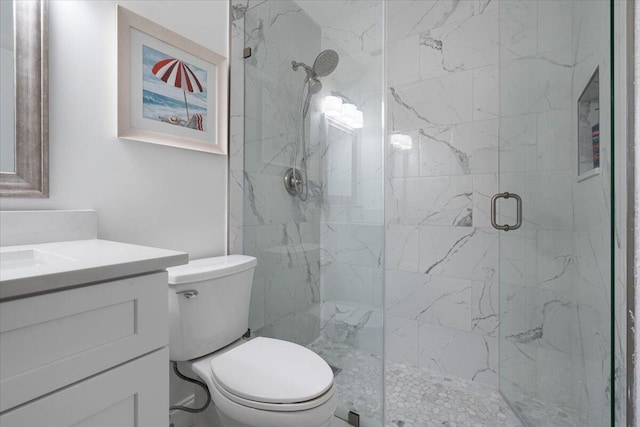 bathroom featuring toilet, an enclosed shower, and vanity