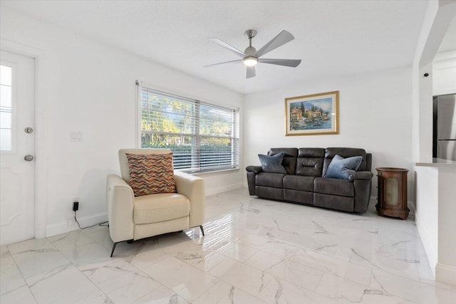 living room with ceiling fan and a textured ceiling