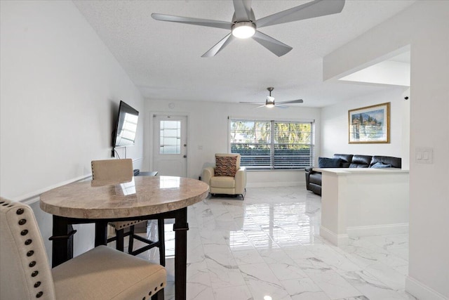 dining space with a textured ceiling and ceiling fan