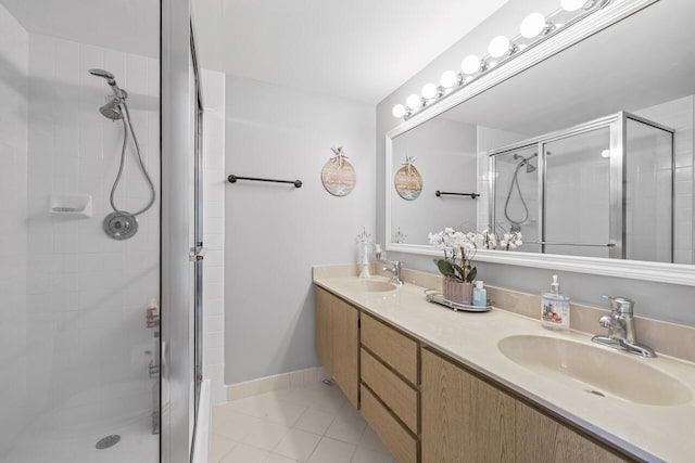 bathroom featuring a shower with shower door, vanity, and tile patterned flooring