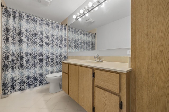 bathroom with toilet, tile patterned floors, and vanity