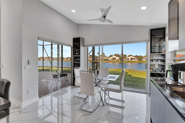 sunroom featuring a water view and ceiling fan